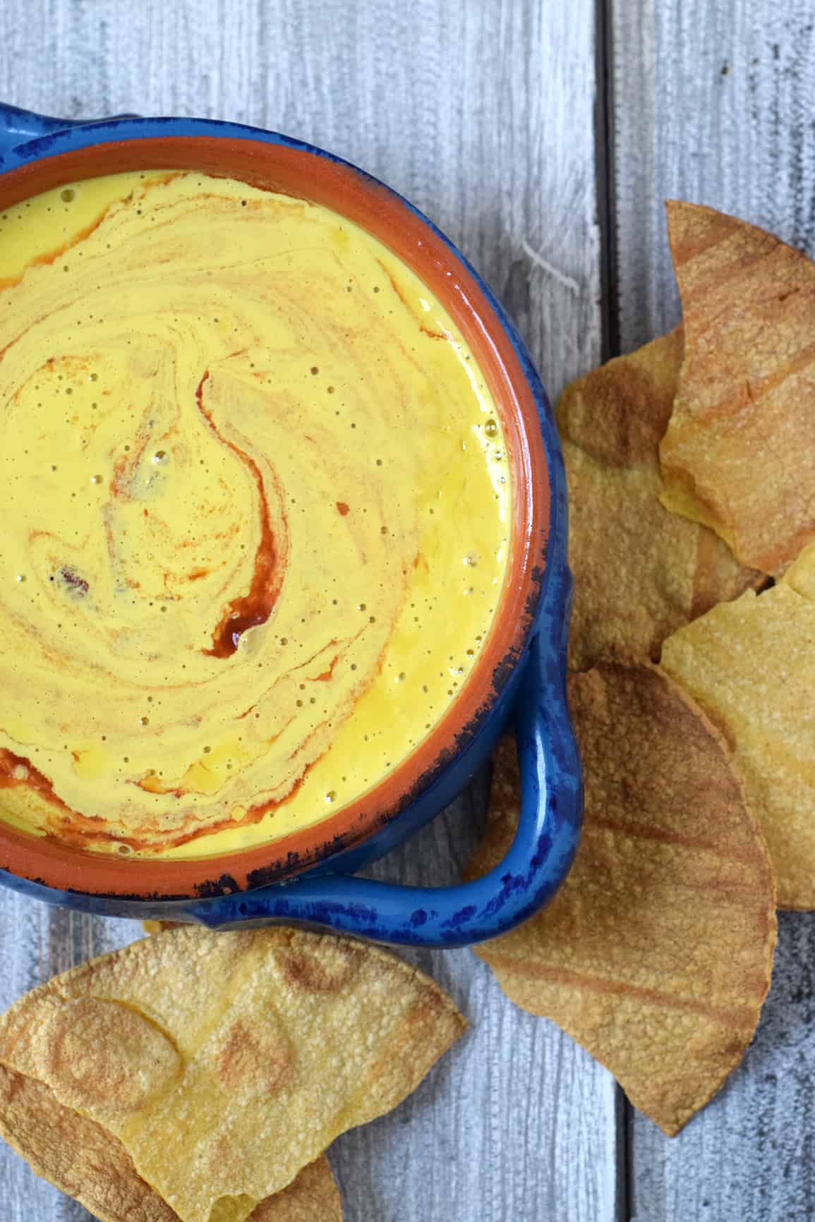 Easy vegan cashew queso in a blue bowl with chips.