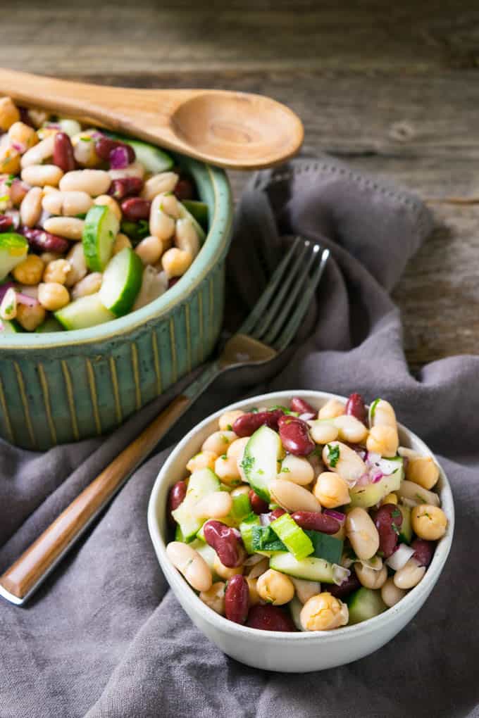 two bowls of three bean salad on napkin with a fork