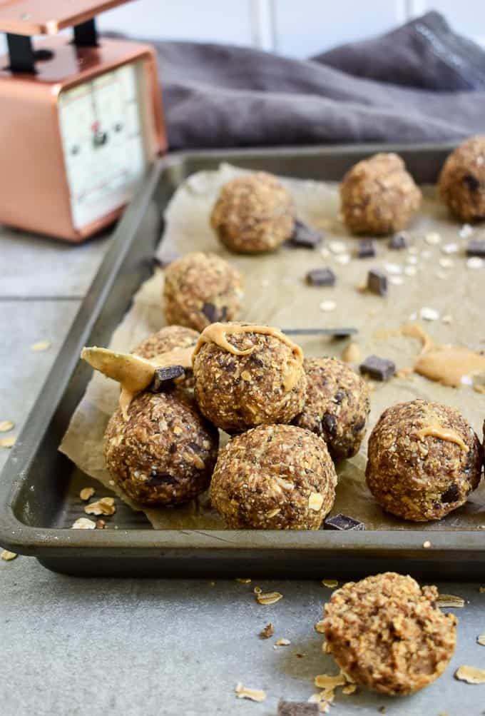Peanut Butter Protein Energy Bites on cookie sheet with spoon.