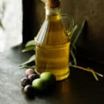 Bottle of olive oil on table.