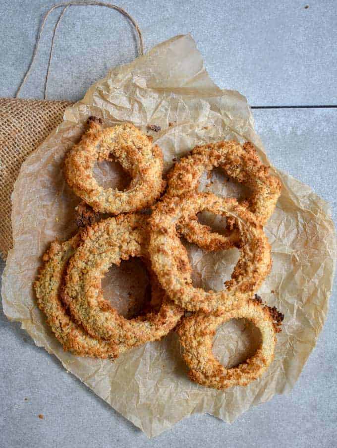 Crunchy baked onion rings on parchment paper.