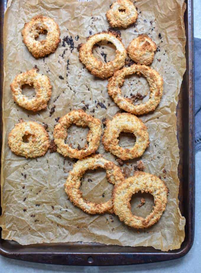 Crunchy baked onion rings cooked on baking pan.