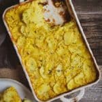 Creamy vegan scalloped potatoes on table with plate.