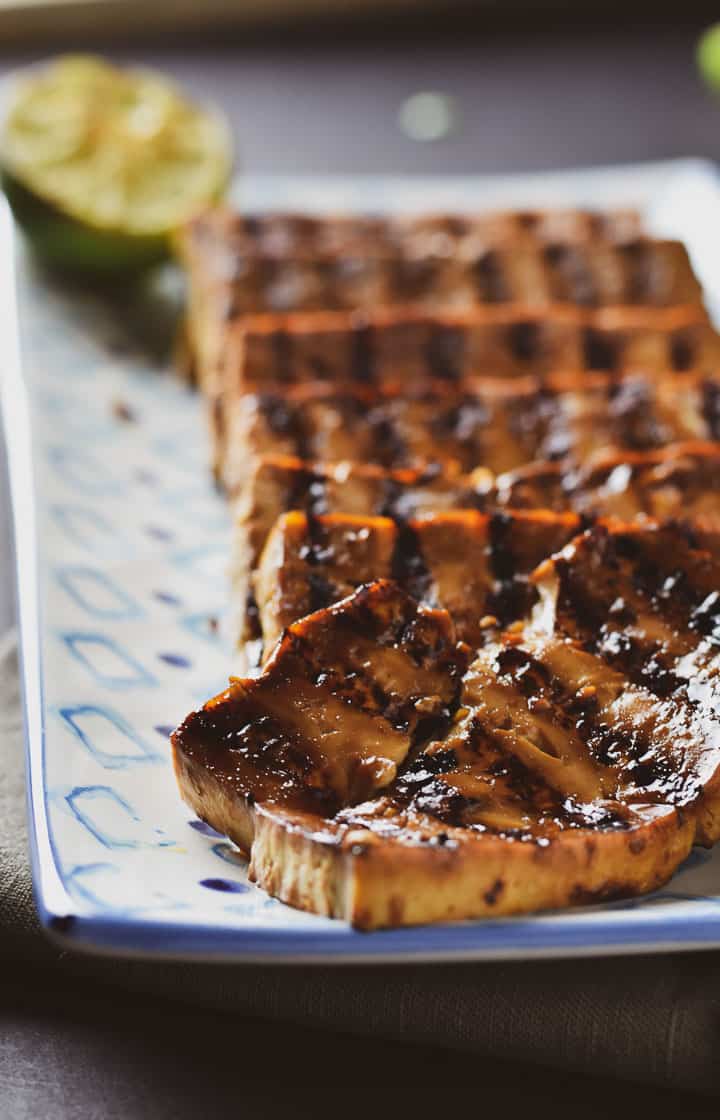 Grilled and marinated tofu slice on serving plate.