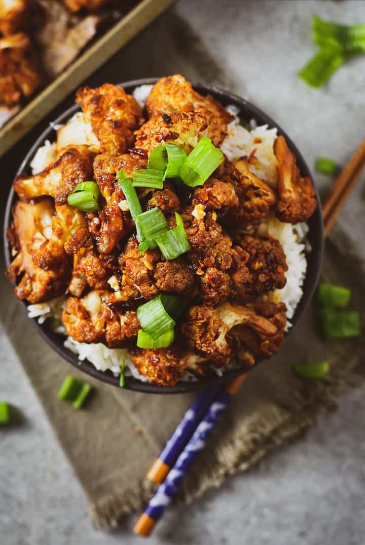 Roasted sweet chili cauliflower on top of rice with green onion.