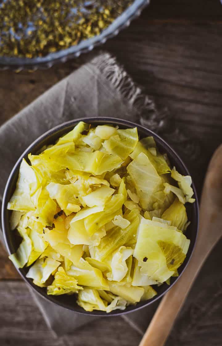 Easy Instant Pot Cabbage on gray napkin with wooden spoon.