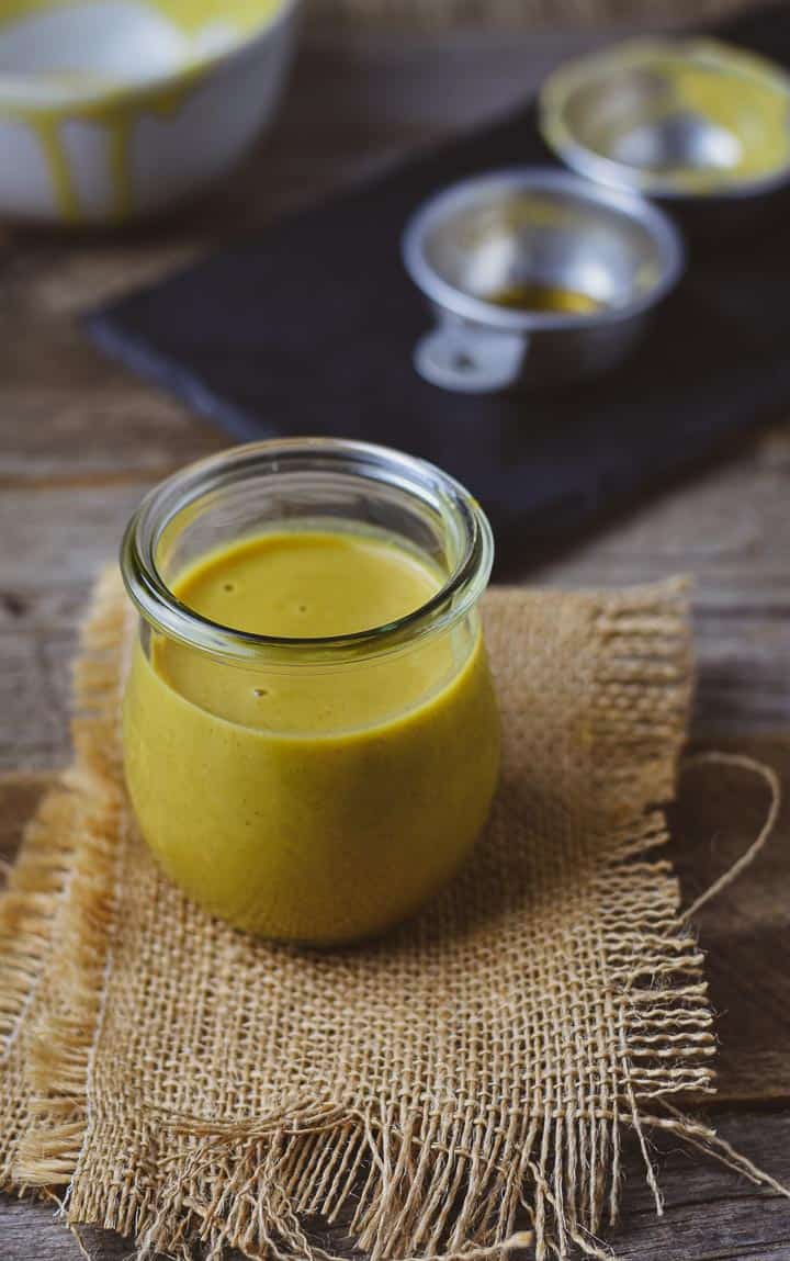 Vegan honey mustard in jar on burlap.