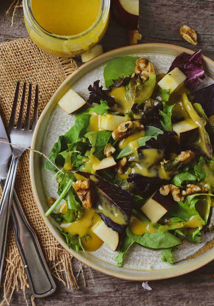 Salad with apples, walnuts, and covered with vegan honey mustard dressing.