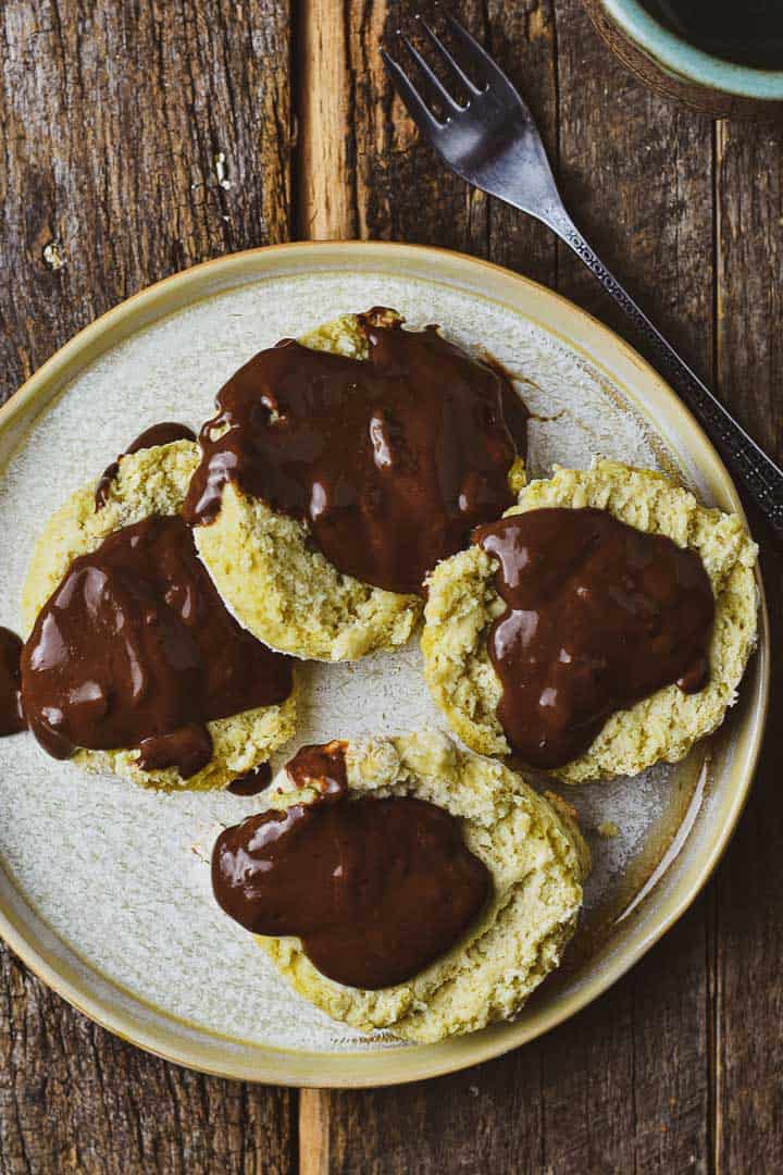 Open faced biscuits on plate with chocolate gravy.