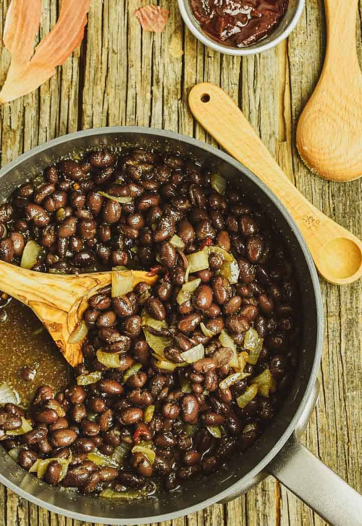 Black beans with onions cooking in pot.