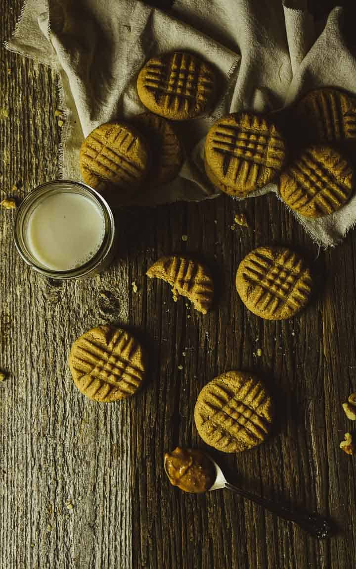 Vegan peanut butter cookies on table with glass of milk.
