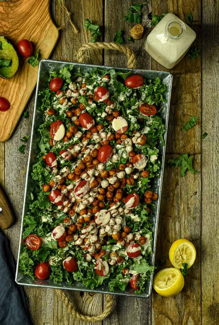 Chipotle chickpea kale salad topped with tomatoes.