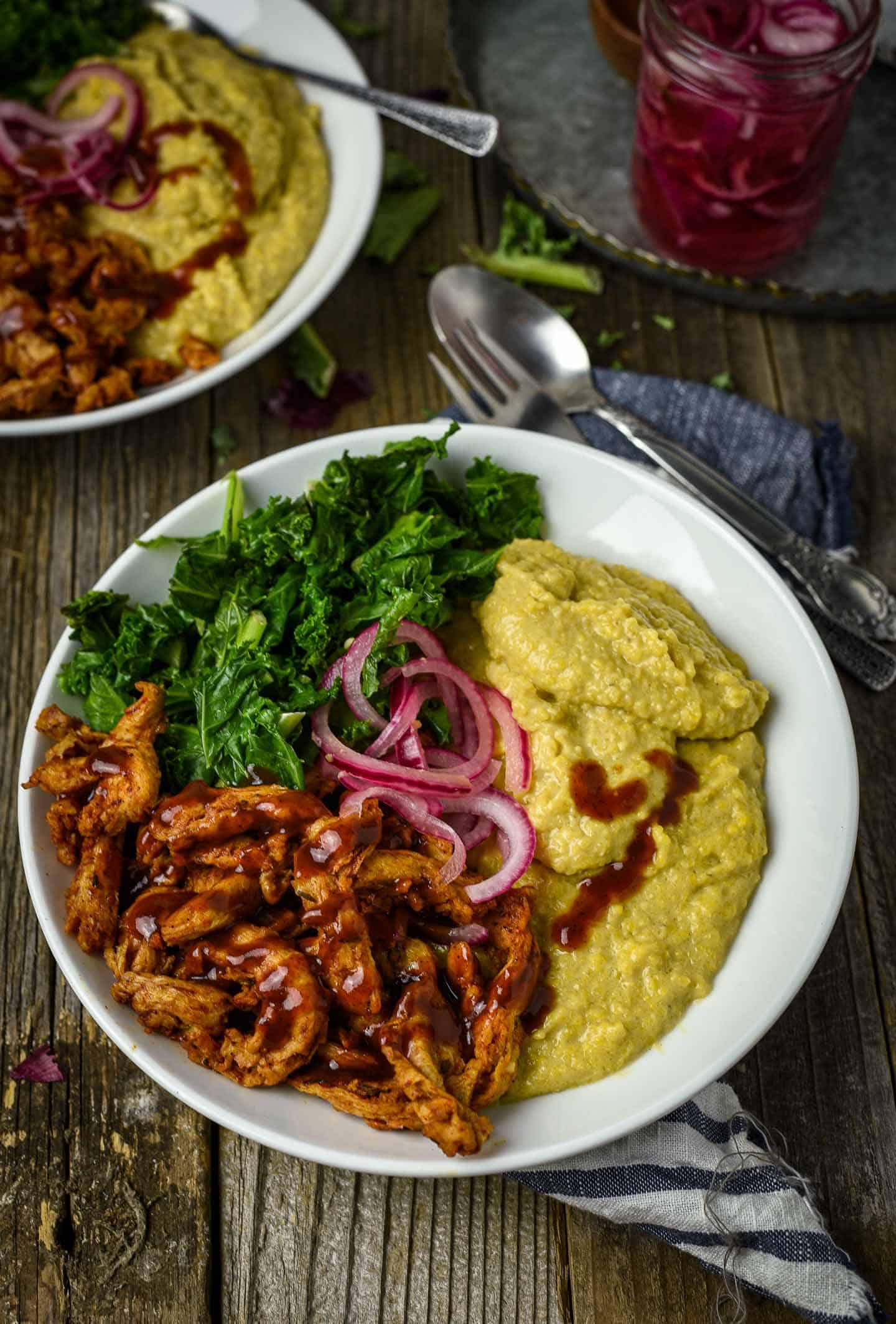 Vegan Grits Bowl with BBQ Soy Curls and Sauteed Kale is the definition of comfort food. A delicious and healthy plant-based breakfast bowl featuring creamy cheesy grits, hearty bbq soy curls, and greens.