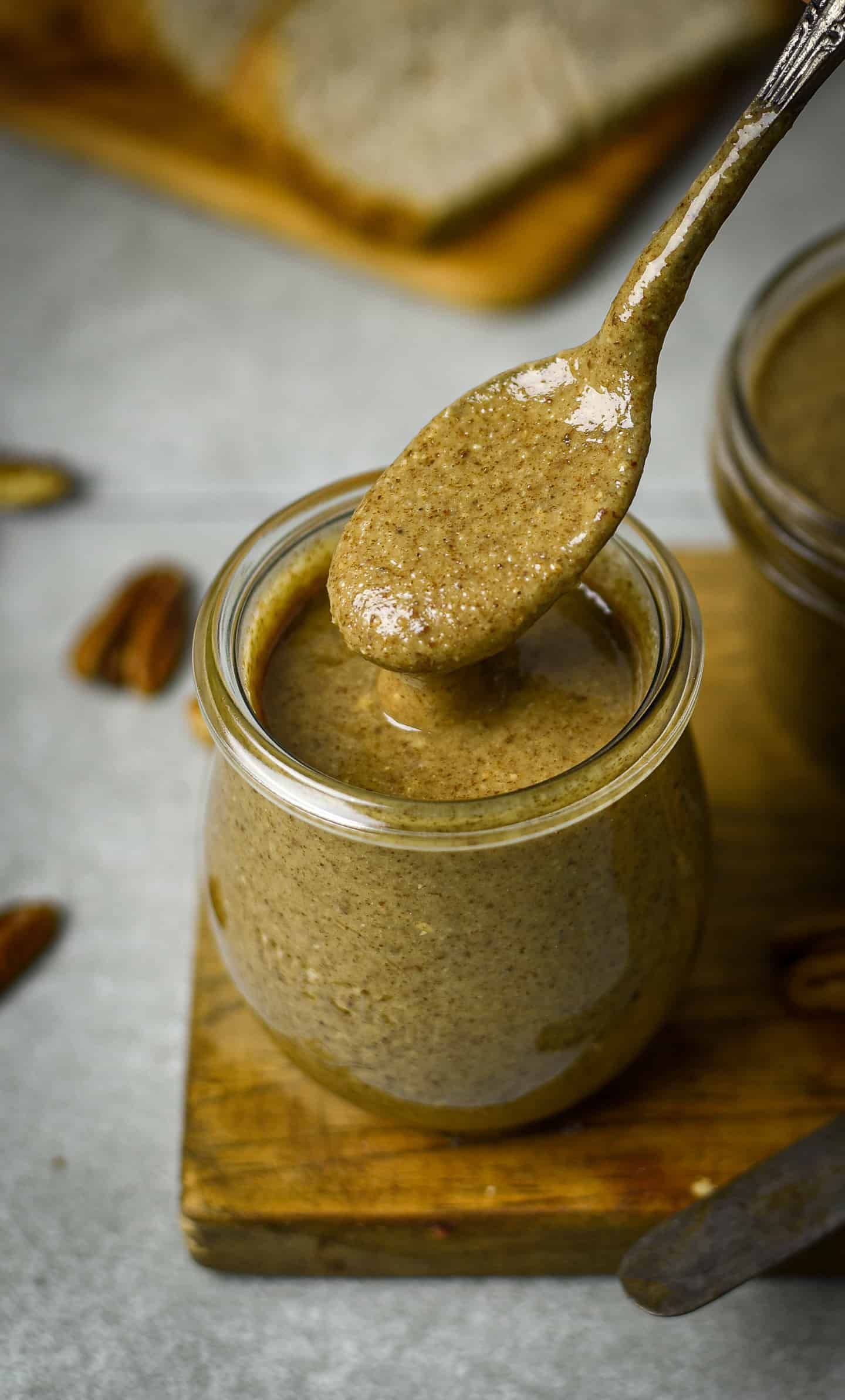 Pecan butter dripping off of a spoon.