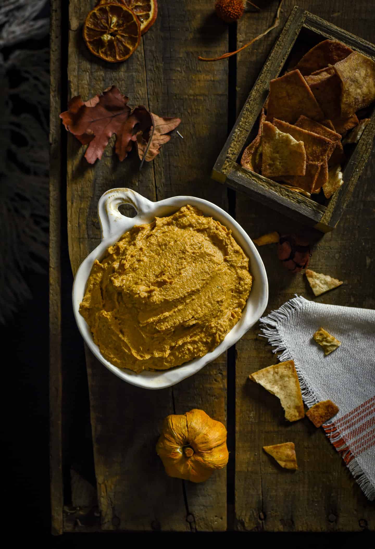 pumpkin pie hummus on bowl on table with pita chips