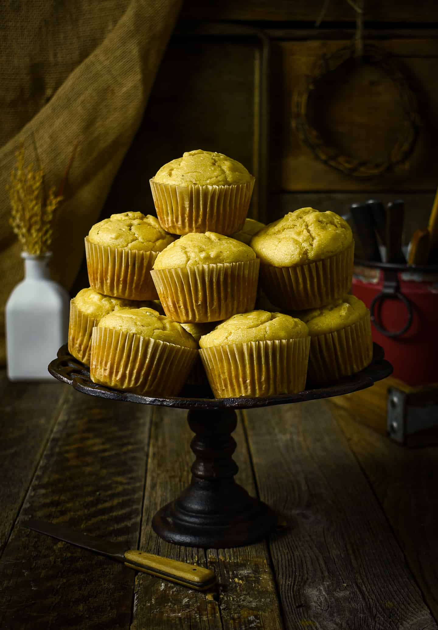 Muffins stacked on top of a cake stand.