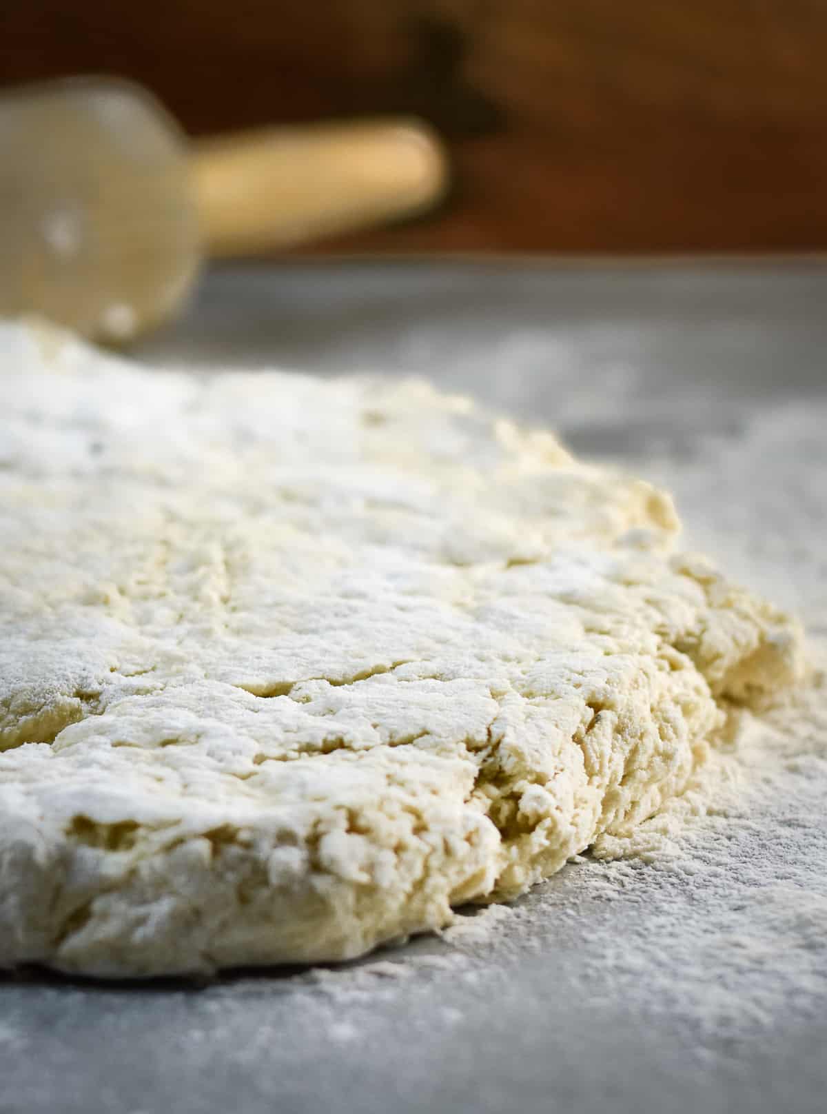 Biscuit dough rolled out on floured service.