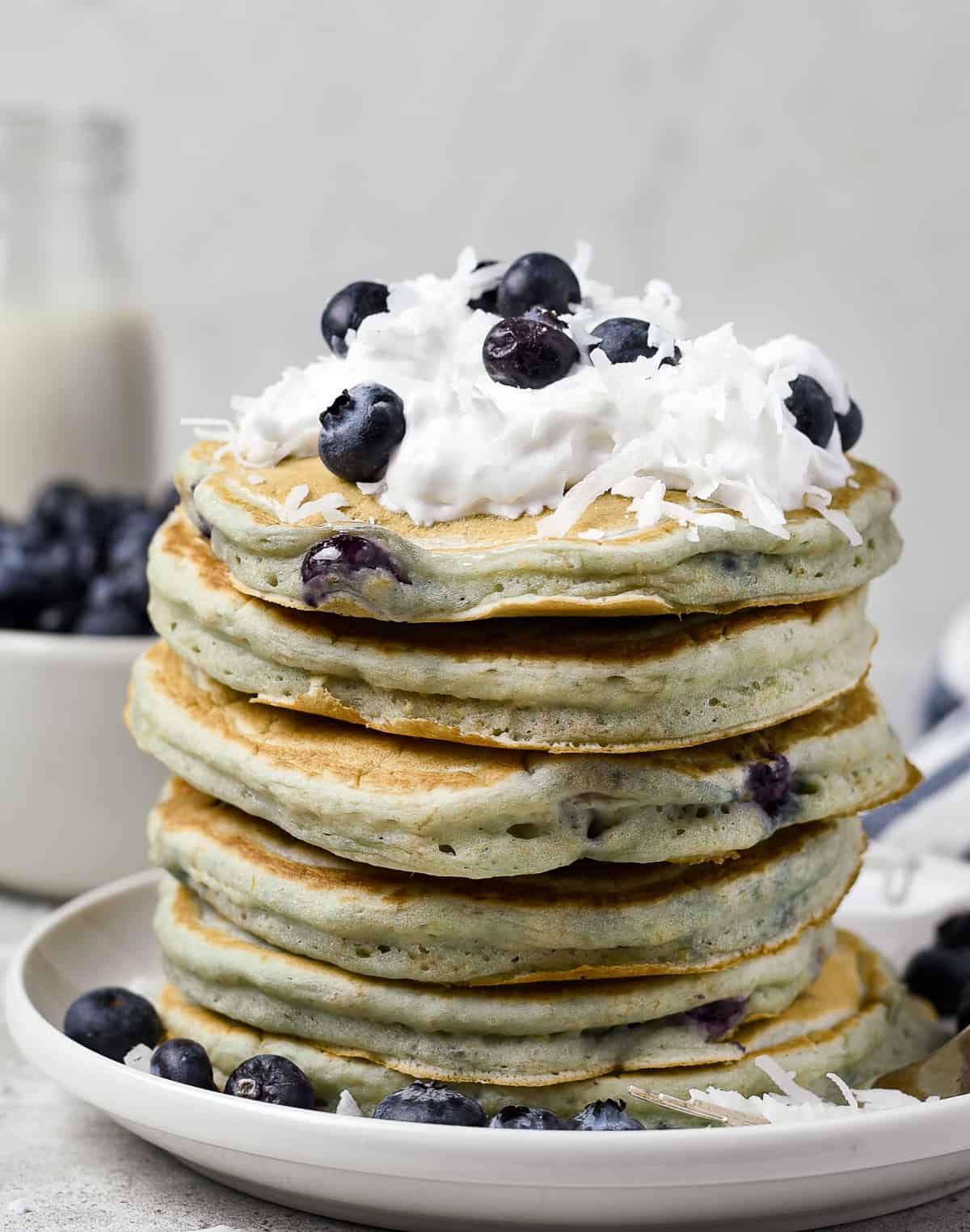 Pancakes with blueberries and whipped cream on top.