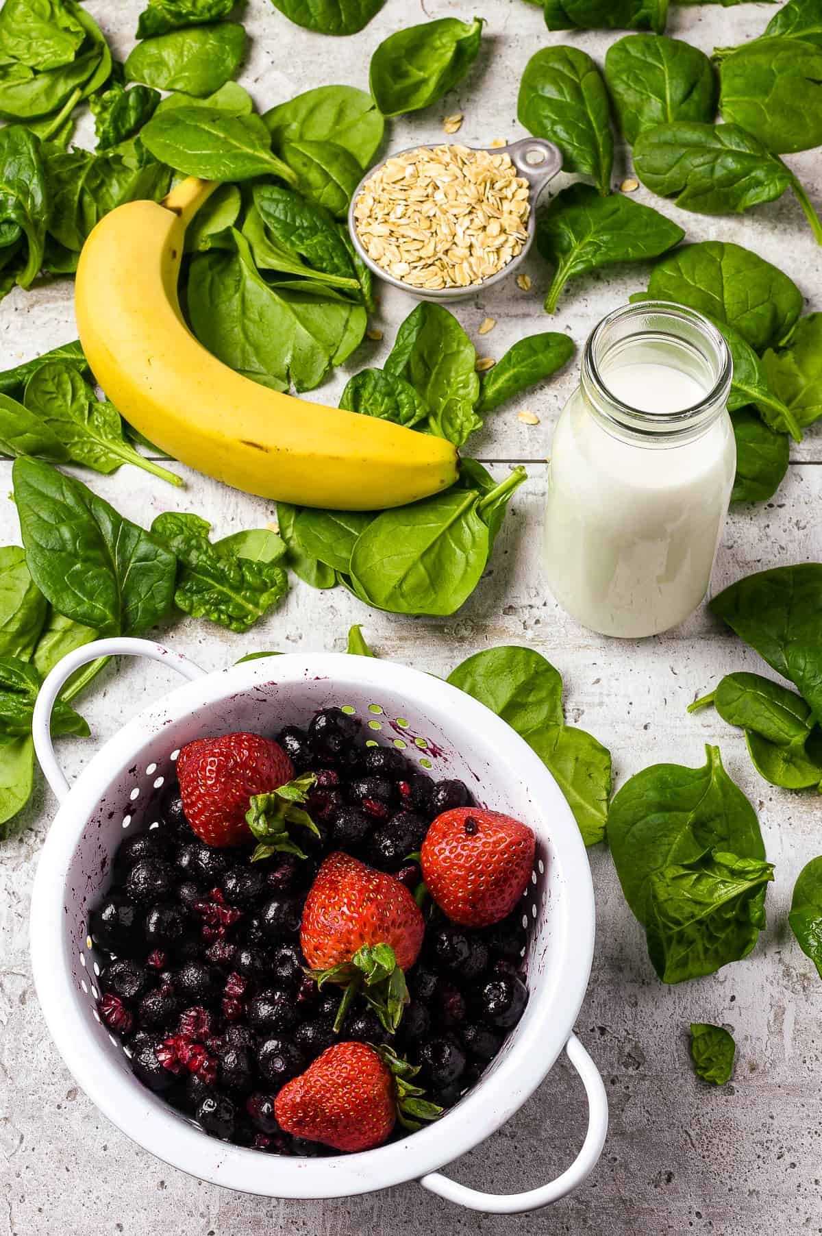 Berries, banana, almond milk, oats on bed of spinach.