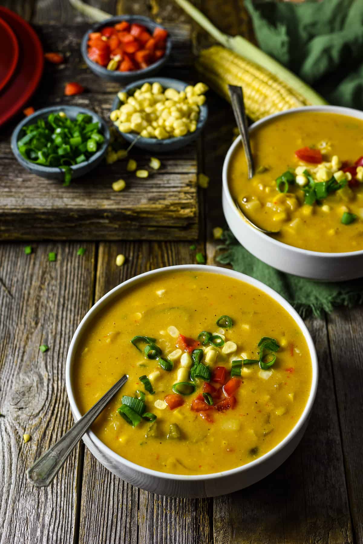 Bowl of corn chowder with corn, onion, and bell pepper garnish.