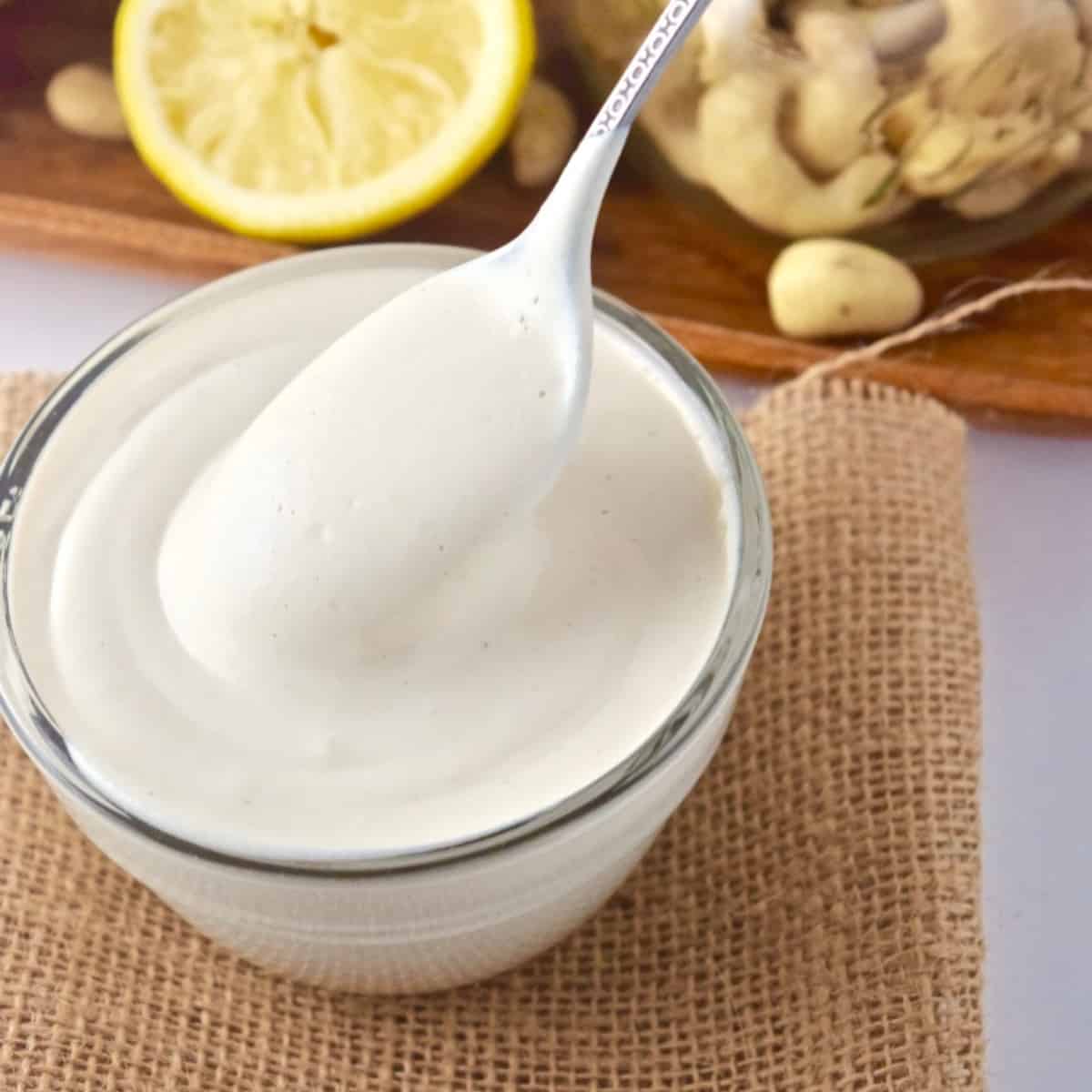 Cashew sour cream in bowl with spoon.