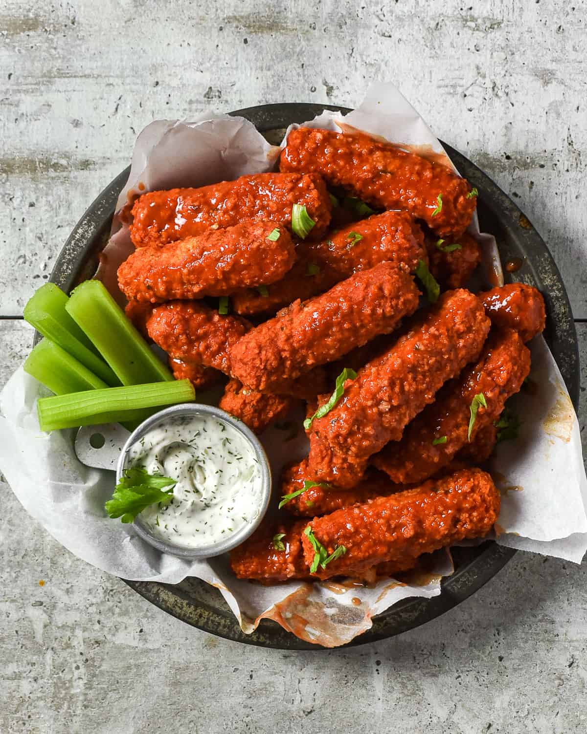 vegan buffalo tofu wings with celery and ranch dressing.