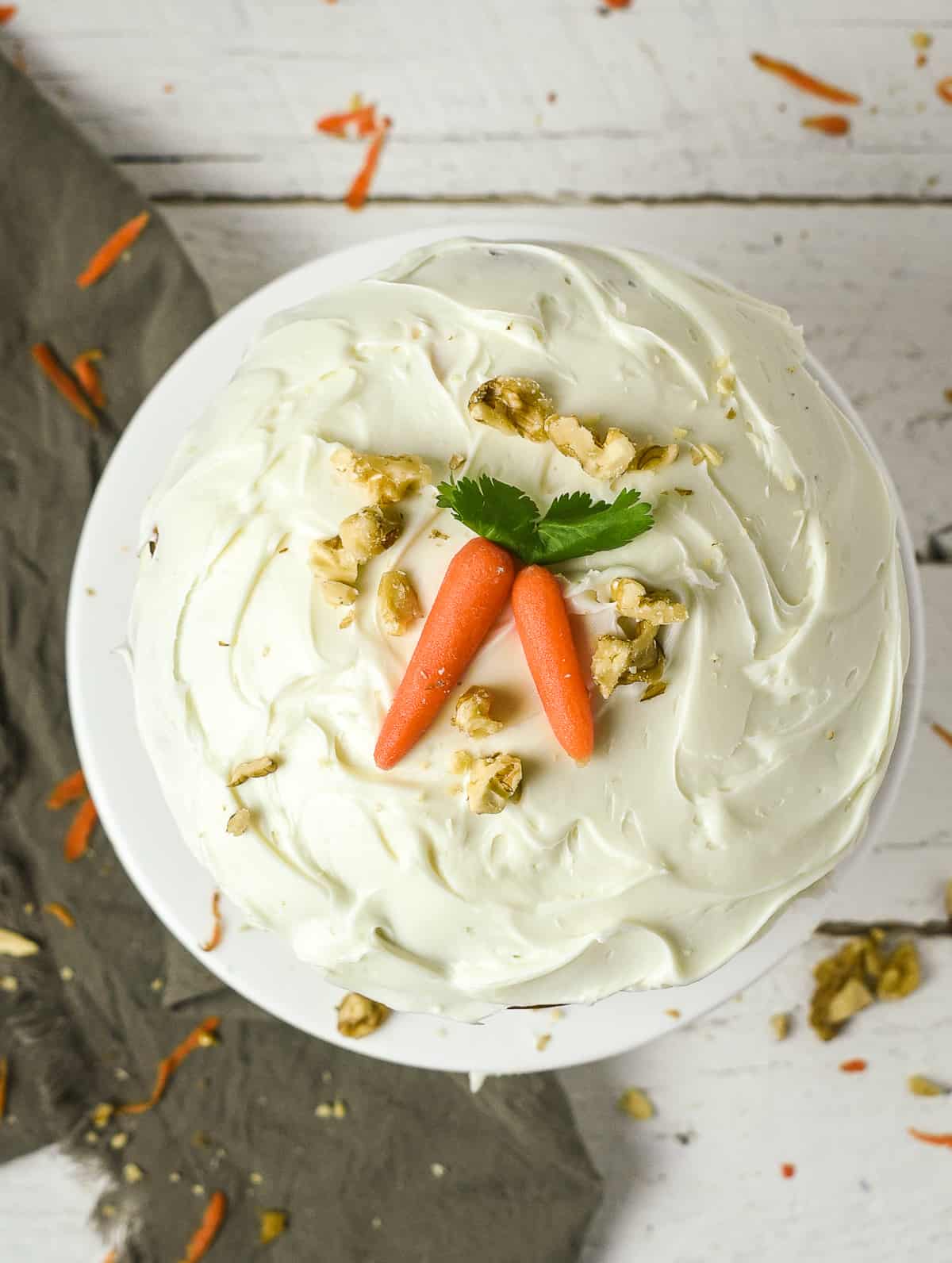 vegan carrot cake with small carrots on top.
