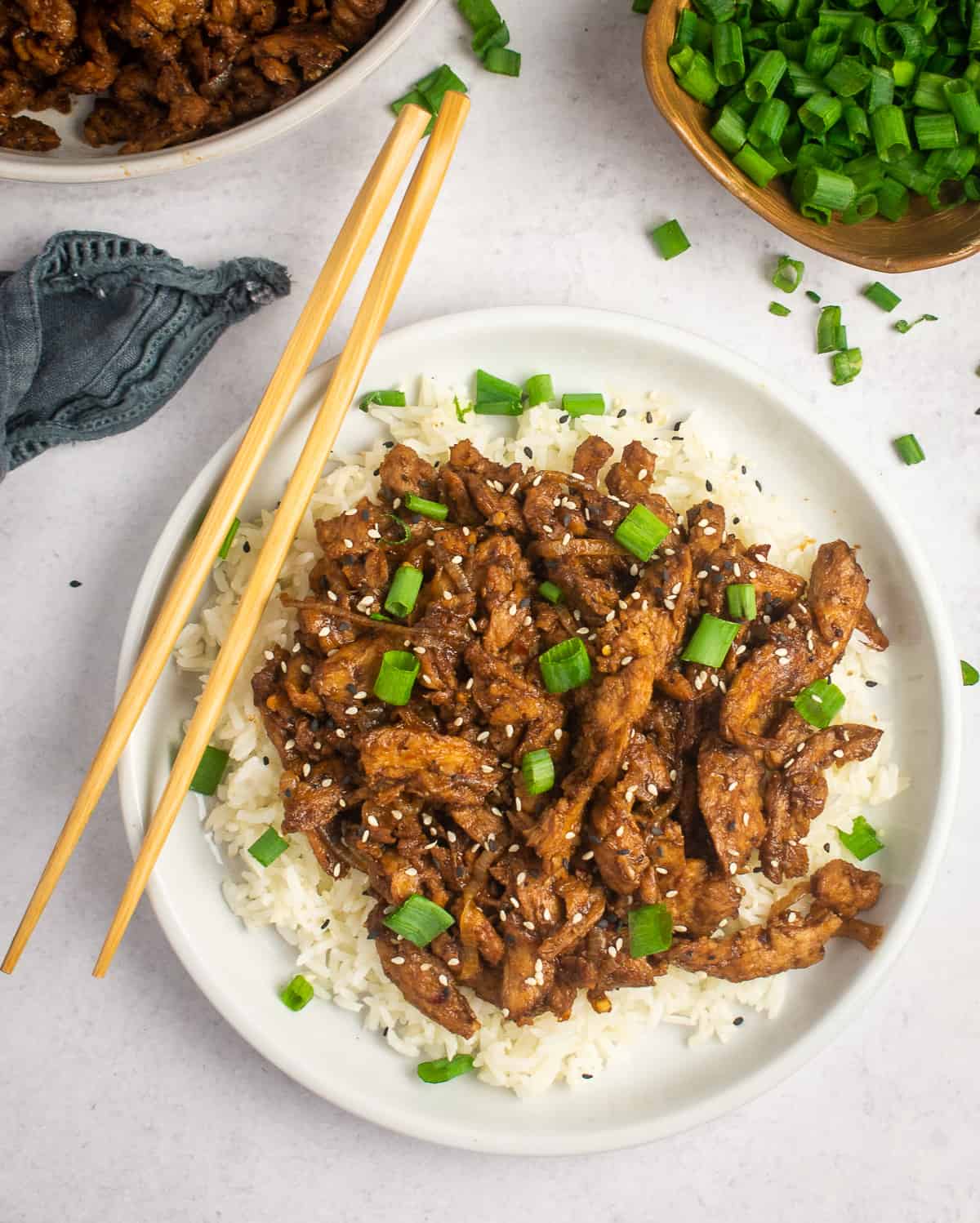 vegan bulgogi on plate with rice and chop sticks.