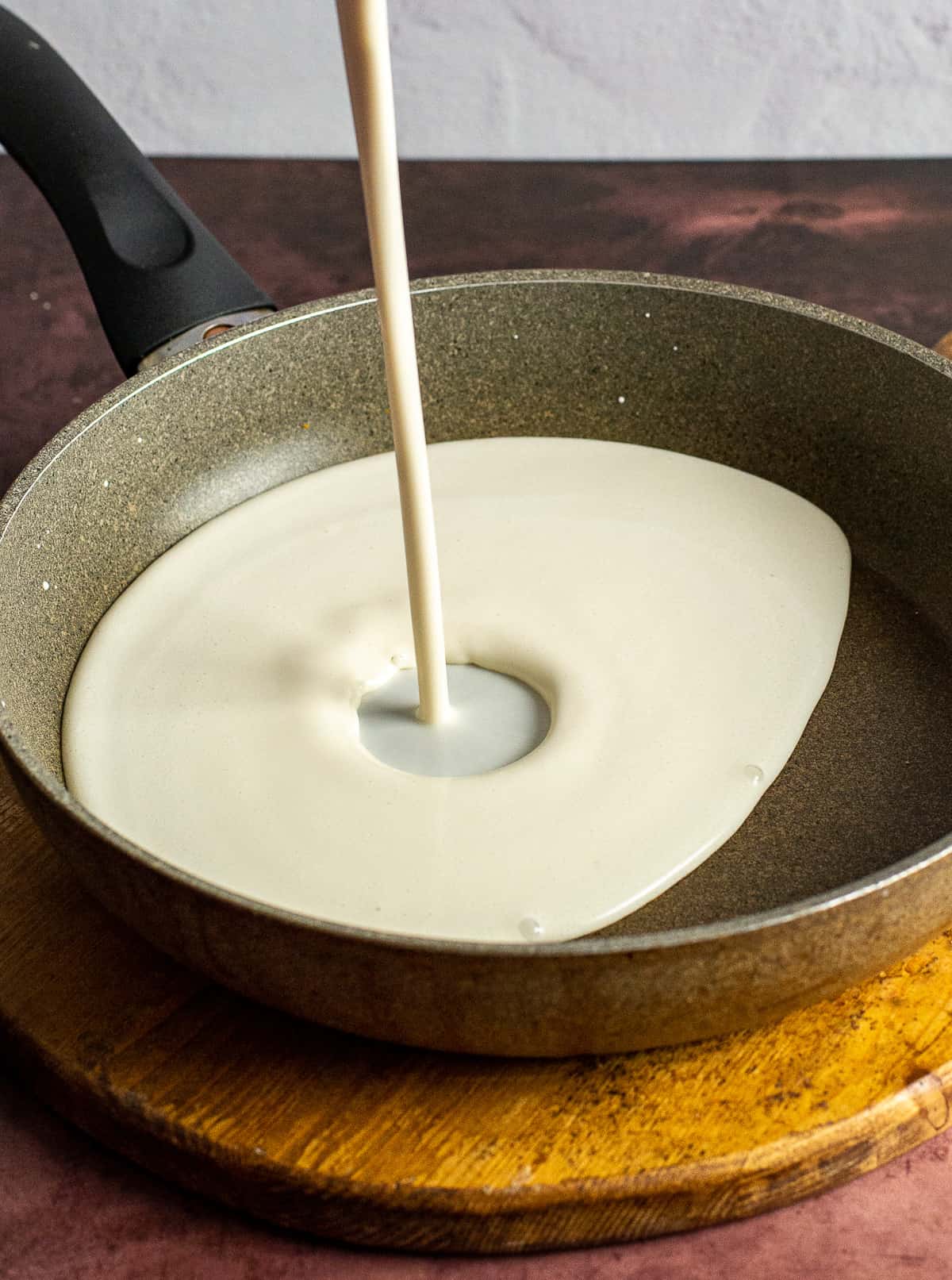 liquid being poured into a nonstick skillet.