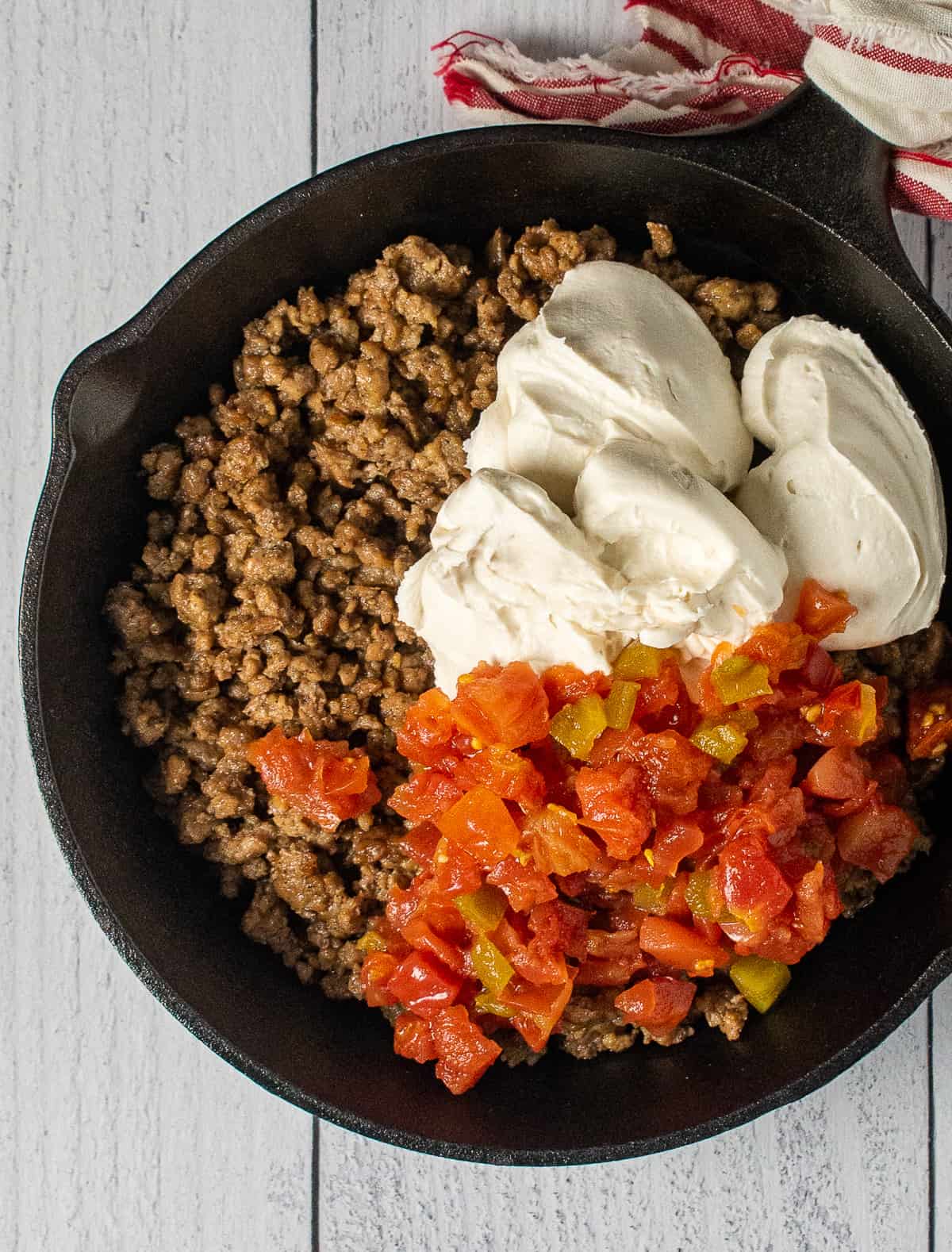 tomatoes, sausage, and cream cheese in skillet