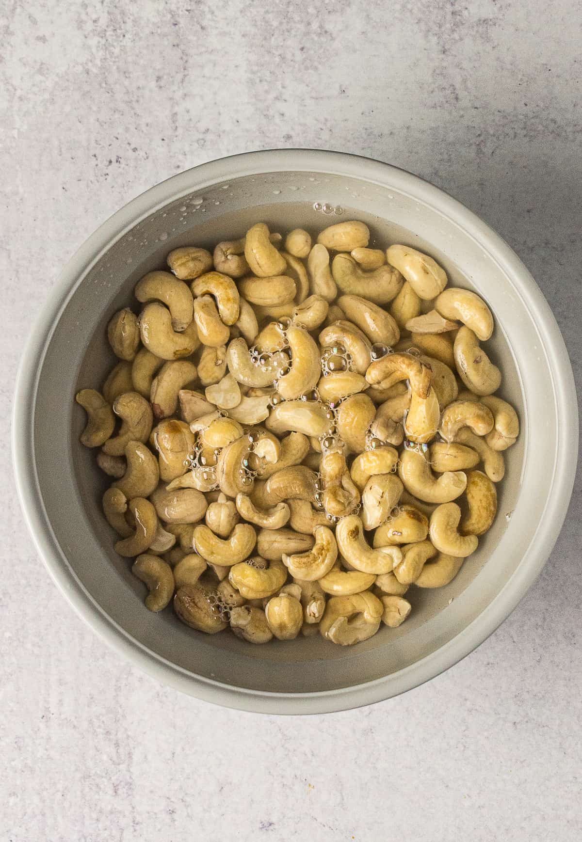 raw cashews soaking in a bowl of water