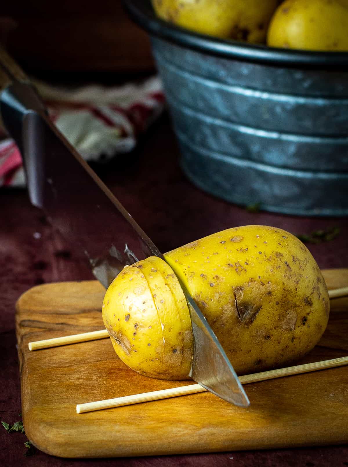 Knife slicing through potato.