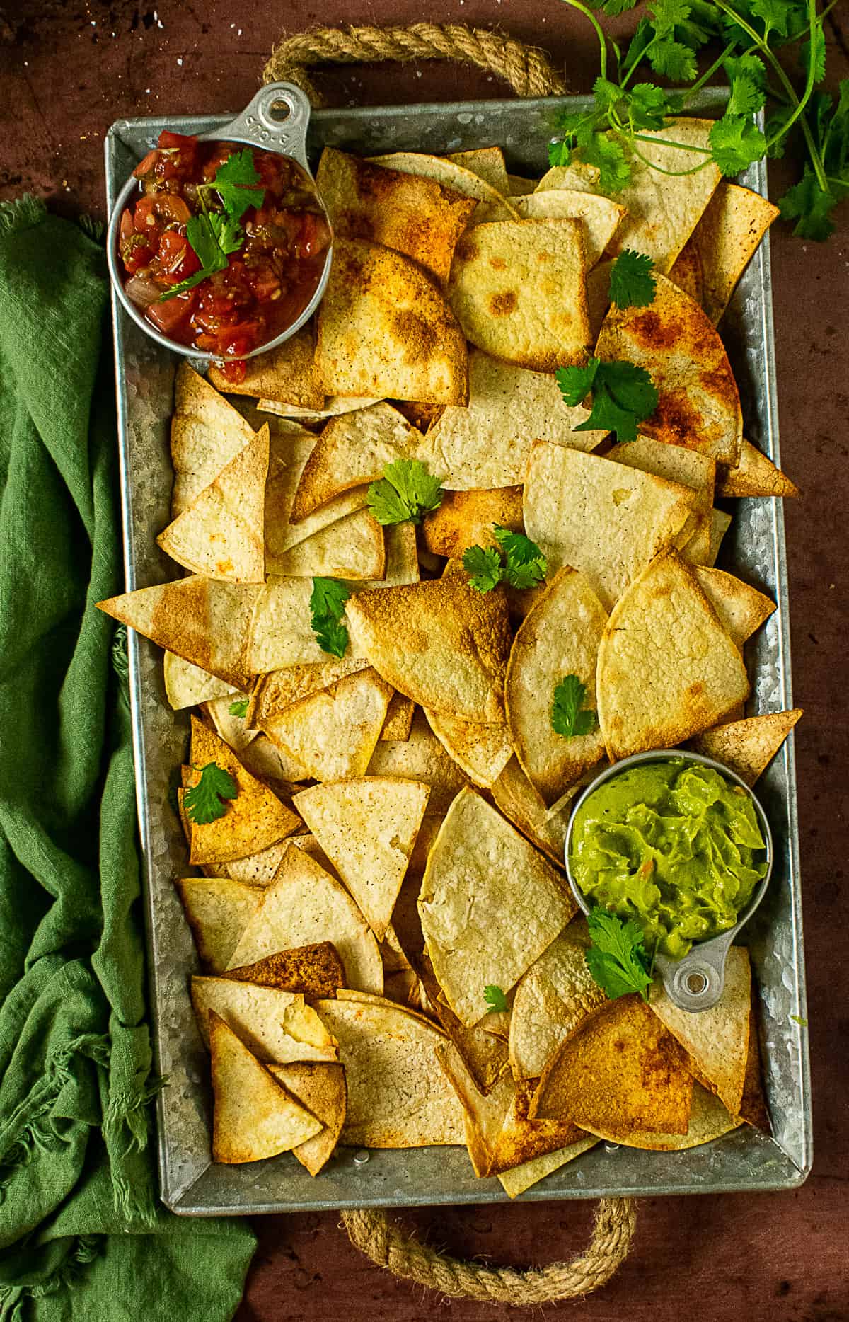 healthy homemade tortilla chips on tray with salsa and guacamole