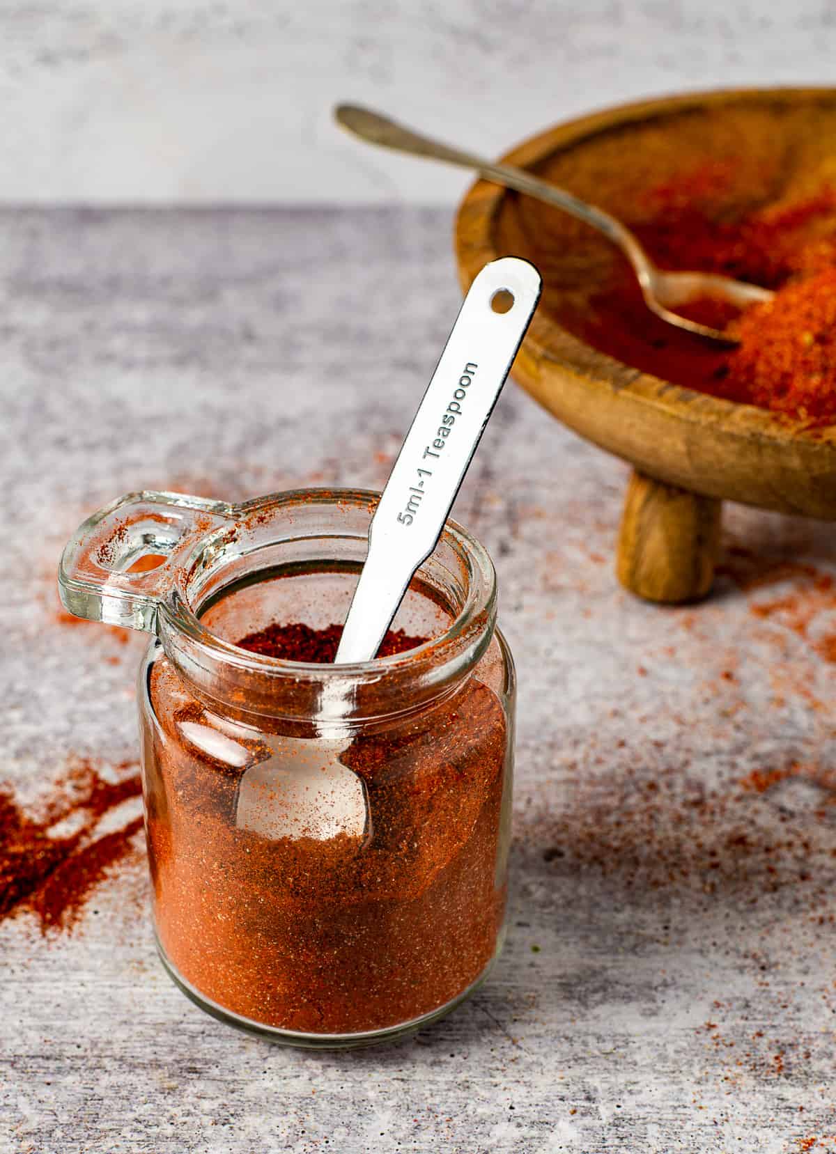 chili powder in jar with measuring spoon