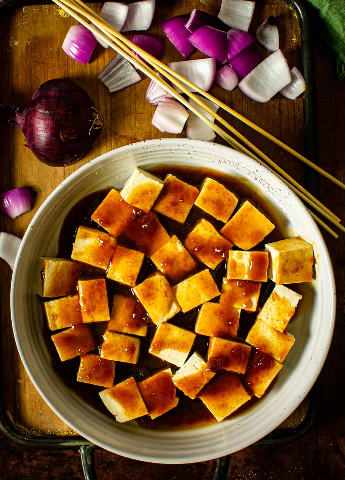 Tofu in bowl with teriyaki sauce.