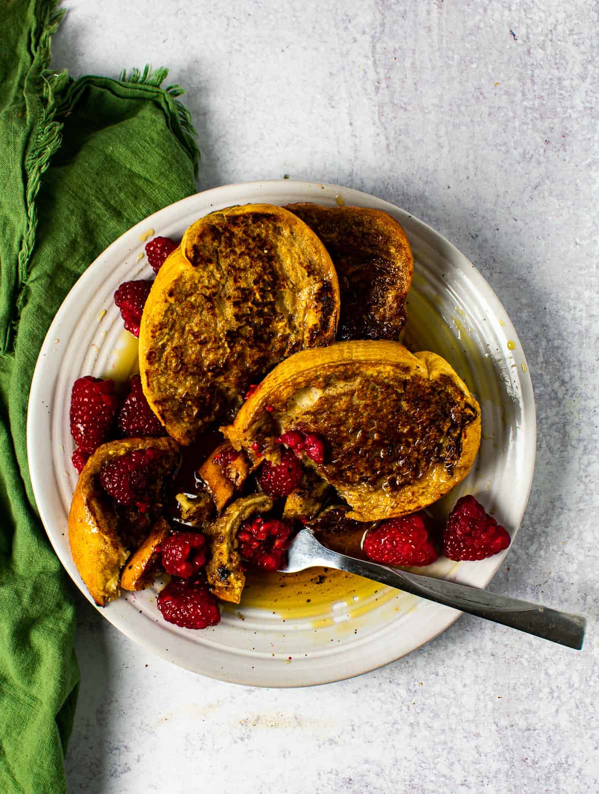 vegan french toast on plate with fork and raspberries