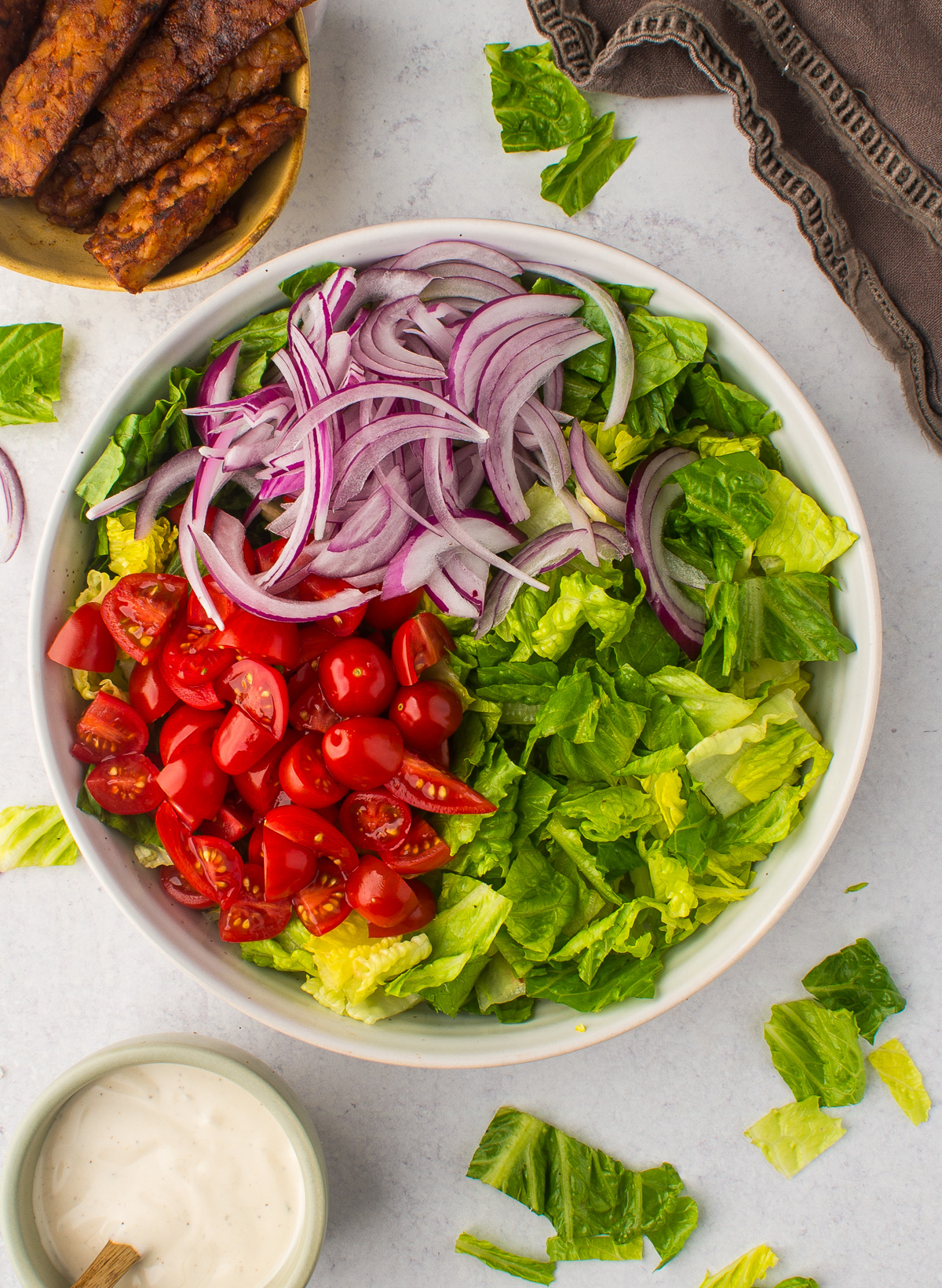 lettuce, red onion, and cherry tomatoes in bowl.