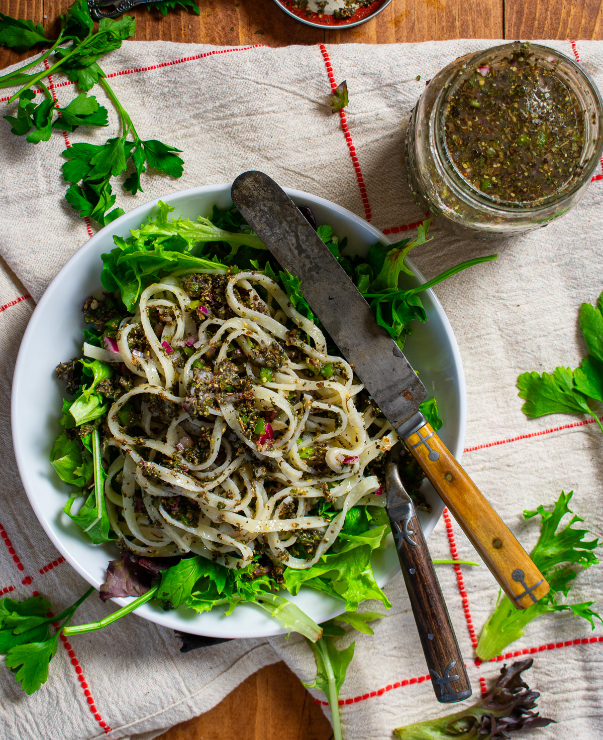 Italian dressing, pasta, and greens in bowl.