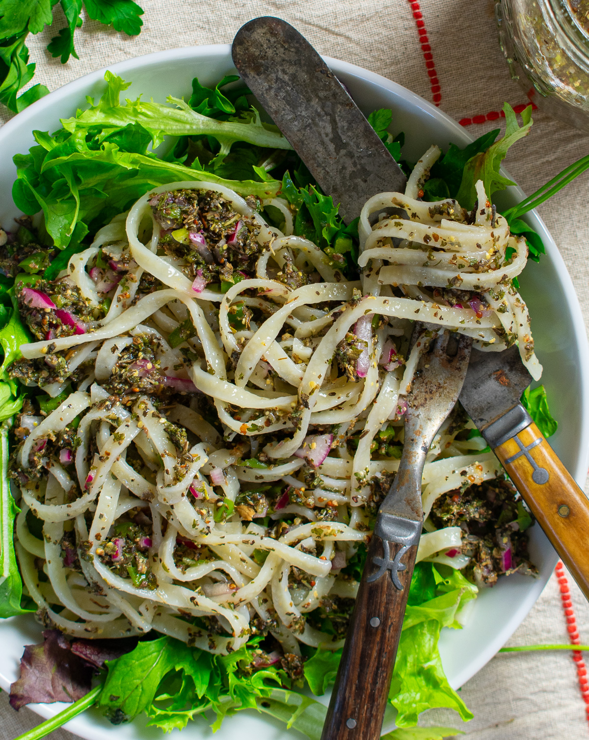 Italian dressing, pasta, and greens in bowl.
