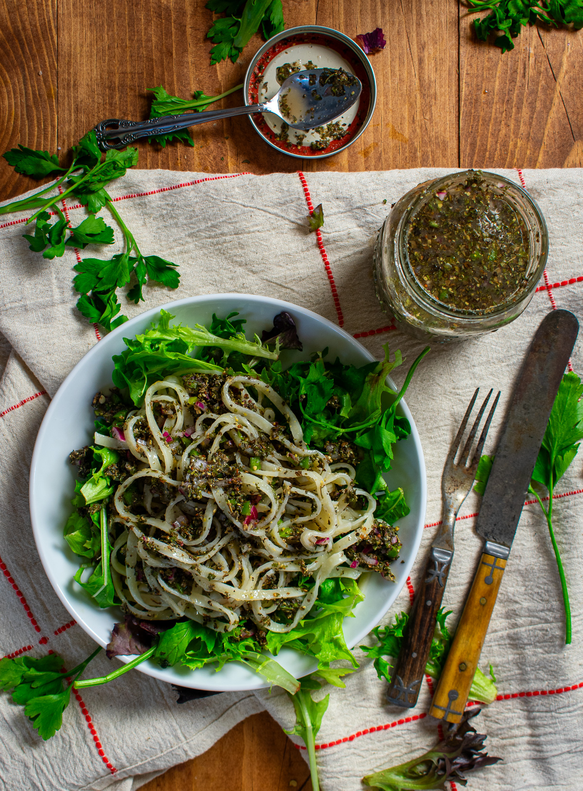 Italian dressing, pasta, and greens in bowl.