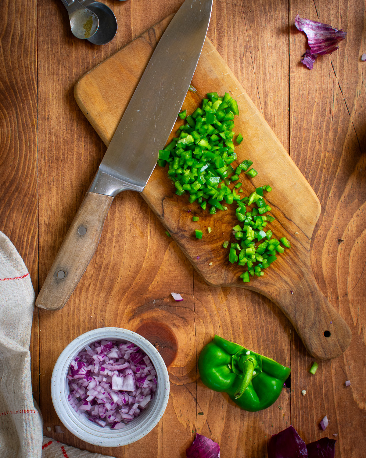 Chopped onion and green pepper on table.